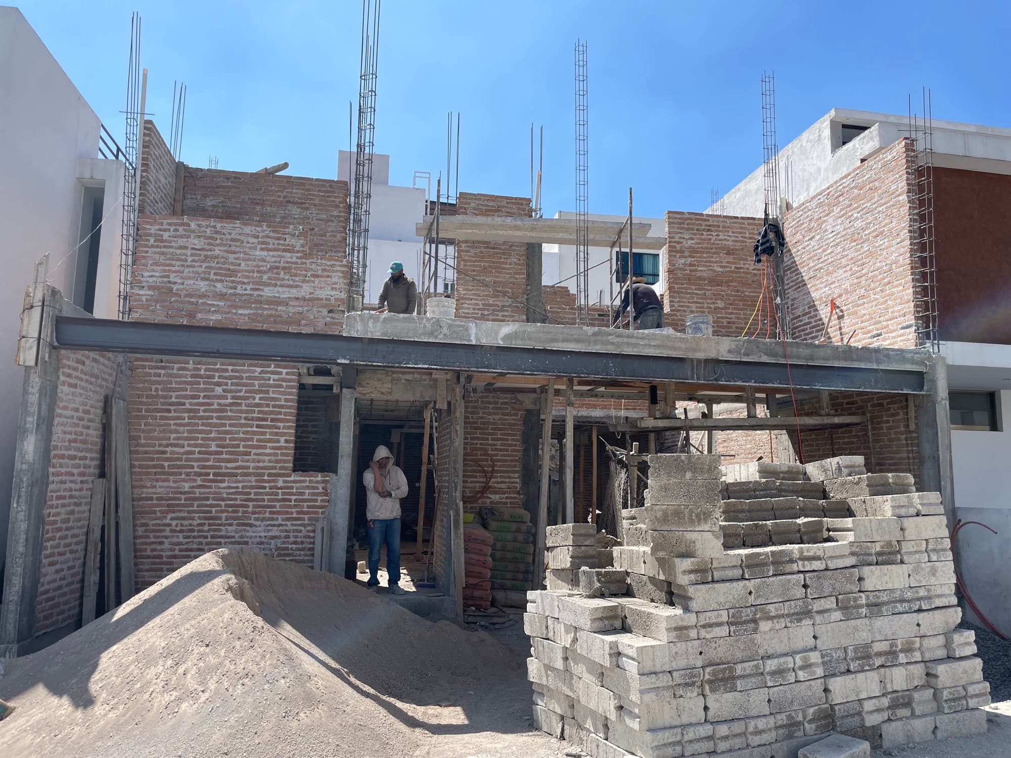 Obra negra de la casa en Zibatá: muros de tabique y material apilado en el terreno